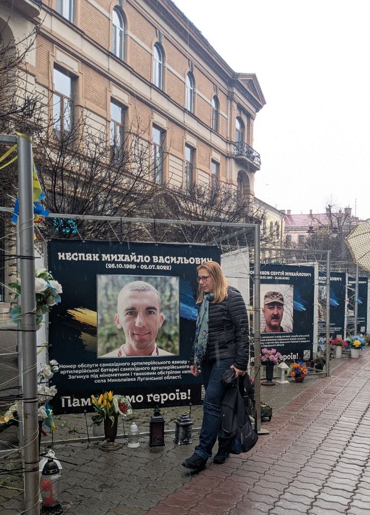 Светлана Скрипнюк смотрит на баннер с портретом сына